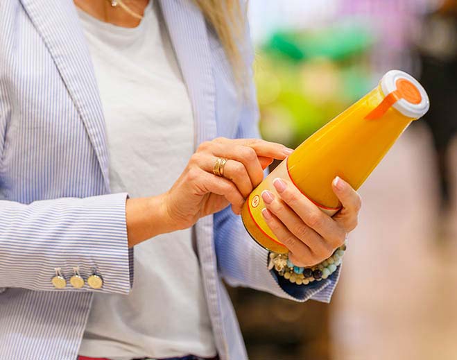 lady reading nutrition label on beverage