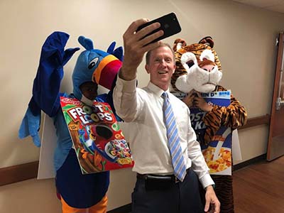 CEO Mark Nosacka taking selfie with cereal mascots